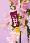 AvryBeauty’s Plum Delight Lip & Cheek Tinted Balm vegan makeup displayed on top of a purple floral background.