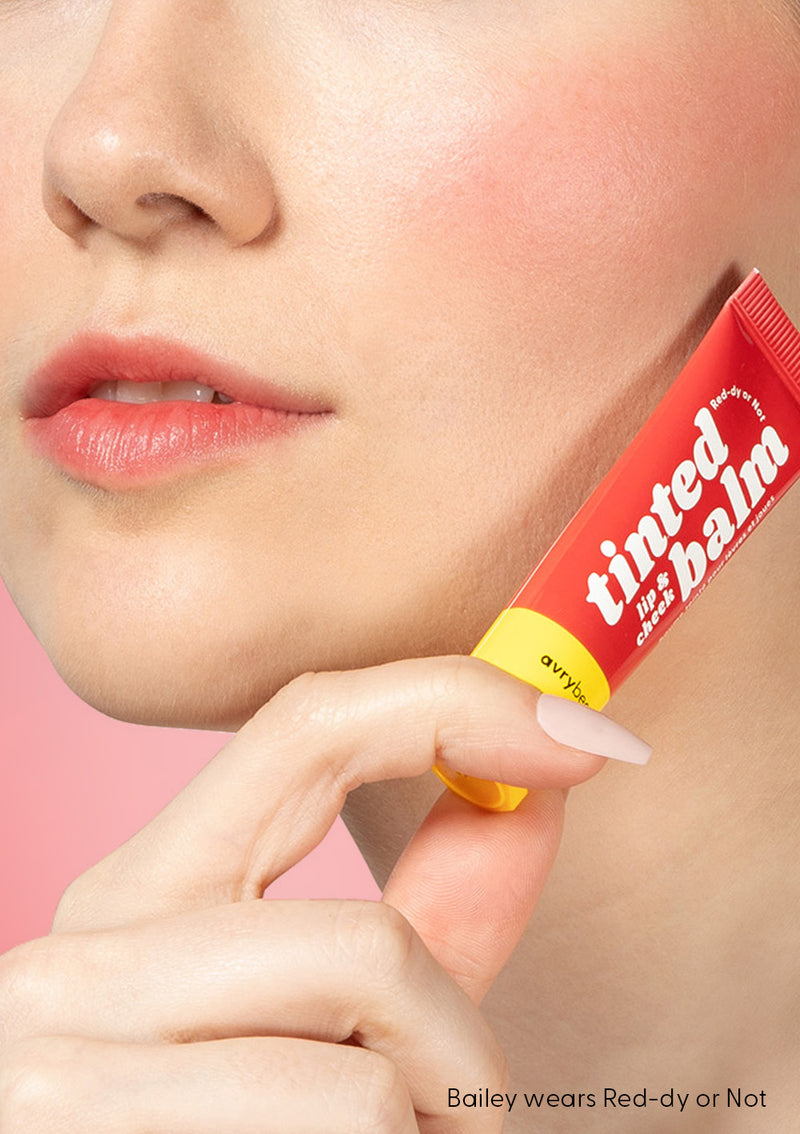 Bailey holding red-dy or not tinted balm on her lips and cheeks