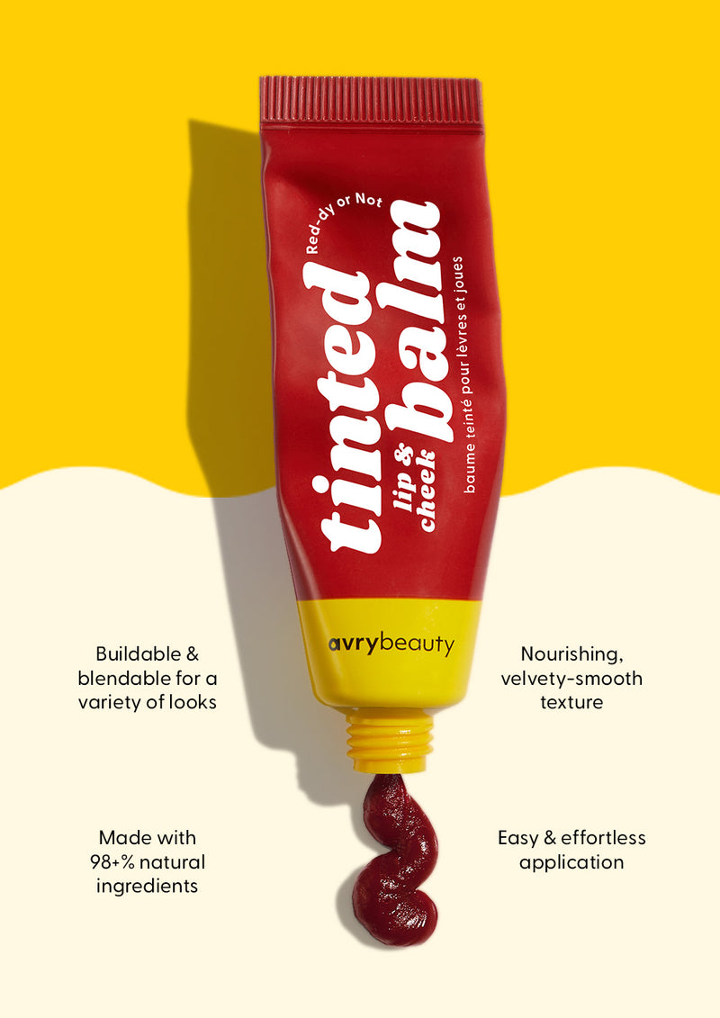 AvryBeauty’s Red-dy or Not Vegan Lip & Cheek Tinted Balm being squeezed out of the tube onto a beige and yellow background, with four callouts detailing its skin benefits.