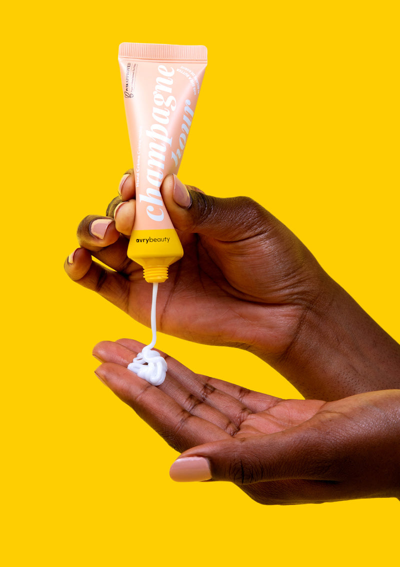 Woman applying Champagne Hour Shea Butter Lotion onto her fingertips for soft and smooth hands.